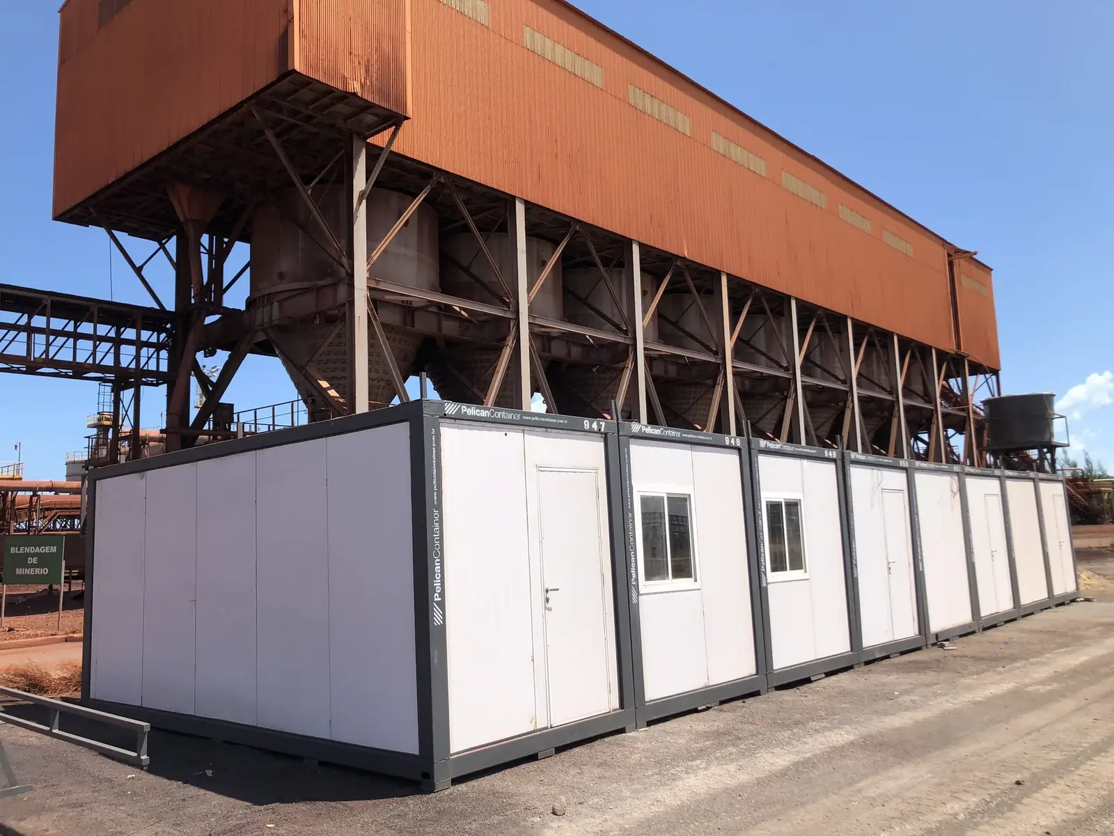 Conjunto de containers modulares brancos instalados em área industrial