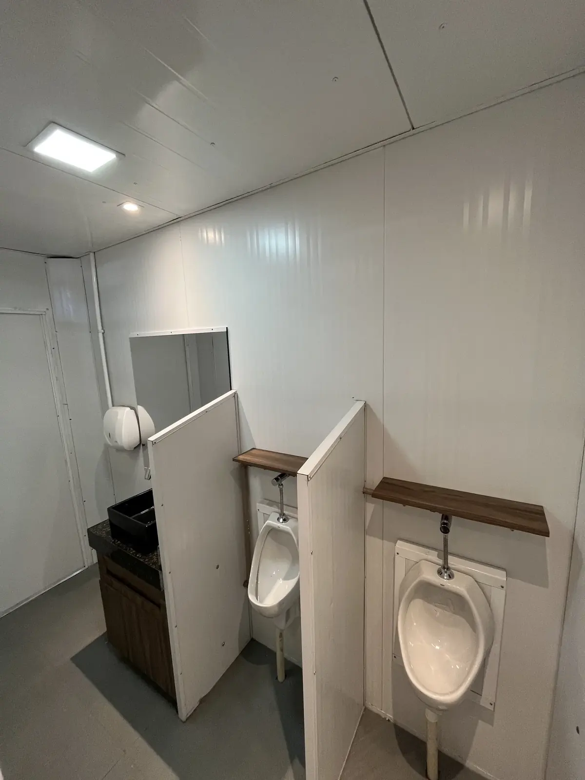 Interior de container sanitário com mictórios e bancada